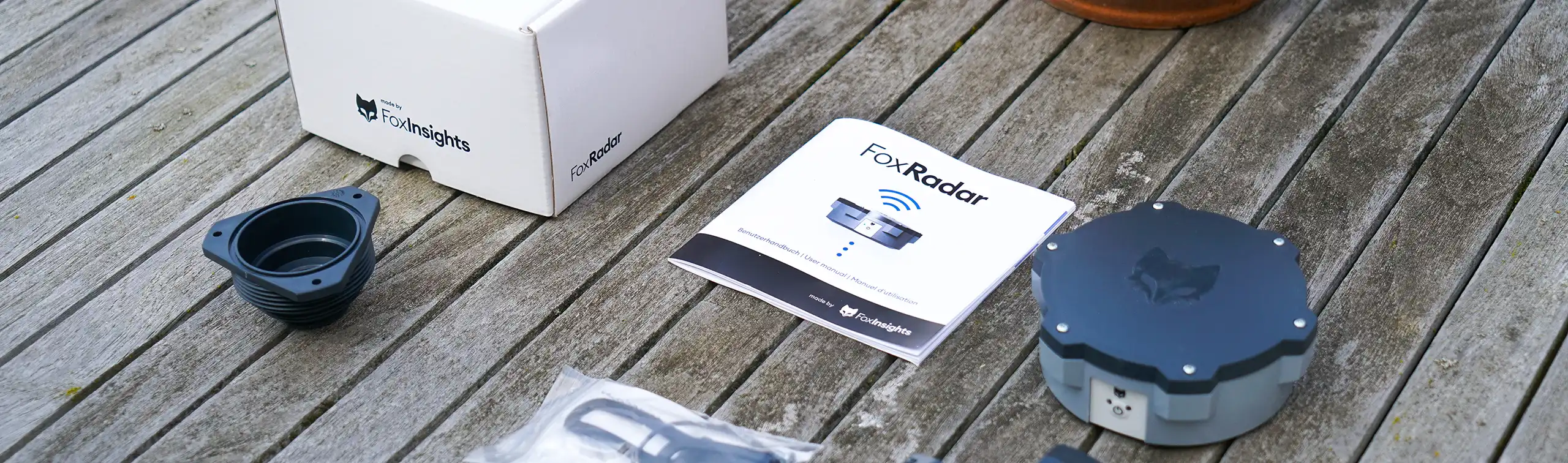 A Foxradar heating oil monitor unboxed on a garden table.